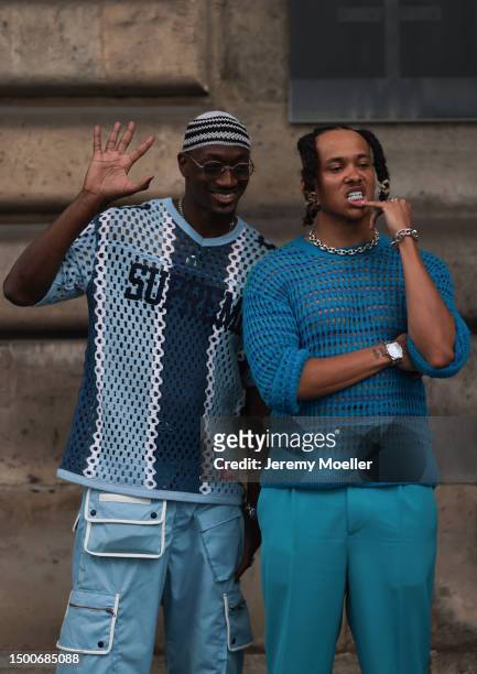 Fashion Week guest is seen wearing a transparent Supreme blue logo shirt, blue Cargo pants and knit blue striped hat the other one is wearing a...