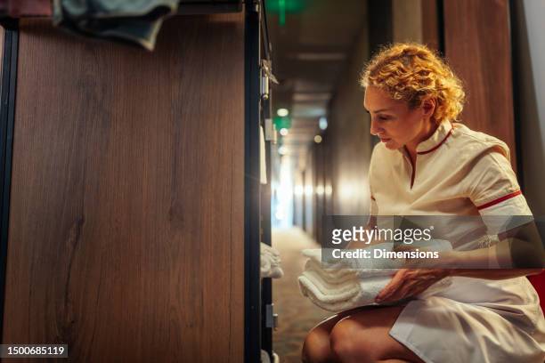blonde maid holding clean towels - house cleaner stock pictures, royalty-free photos & images