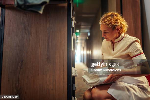 blonde maid holding clean towels - housekeeping uniform stock pictures, royalty-free photos & images