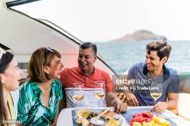 family drinking wine and talking during a yacht trip - pacific_plate stock pictures, royalty-free photos & images