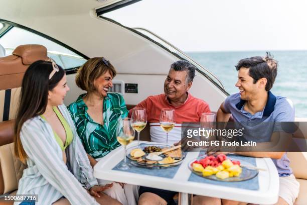 family drinking wine and talking during a yacht trip - pacific_plate stock pictures, royalty-free photos & images