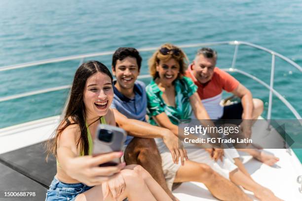 family taking a selfie with mobile phone during a yacht trip - tour boat stock pictures, royalty-free photos & images
