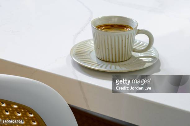 high angle view of a cup of long black coffee on white table - crema stock pictures, royalty-free photos & images