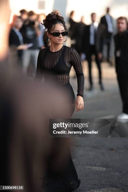 Léna Situations is seen wearing a black Ray Ban shades, gold earrings and transparent black long dress outside Ami Alexandre Mattiussi show during...