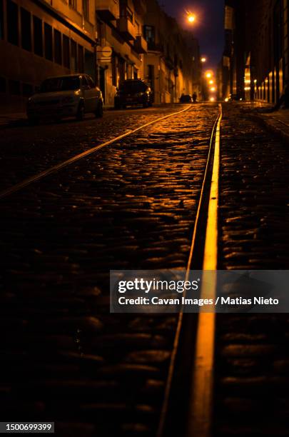 dark street at night with abandoned train rails - buenos aires night stock pictures, royalty-free photos & images
