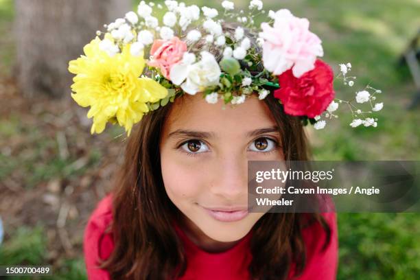 tween girl with live flower head wreath looks up at camera - flower crown stock pictures, royalty-free photos & images