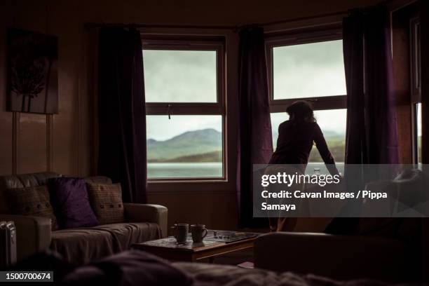 silhouette of girl looking out window at mountain view - window frame ship photos et images de collection