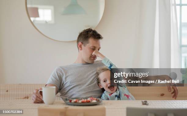 young girl holding her dads nose looking at his breakfast - taquiner photos et images de collection