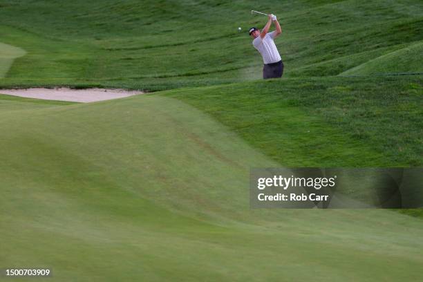 Seamus Power of Ireland plays a shot from a fairway bunker on the 18th hole during the first round of the Travelers Championship at TPC River...