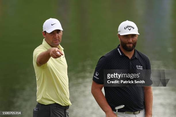 Scottie Scheffler of the United States and Jon Rahm of Spain talk on the 17th green during the first round of the Travelers Championship at TPC River...