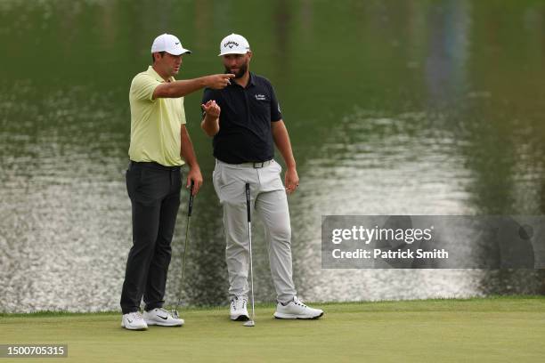 Scottie Scheffler of the United States and Jon Rahm of Spain talk on the 17th green during the first round of the Travelers Championship at TPC River...