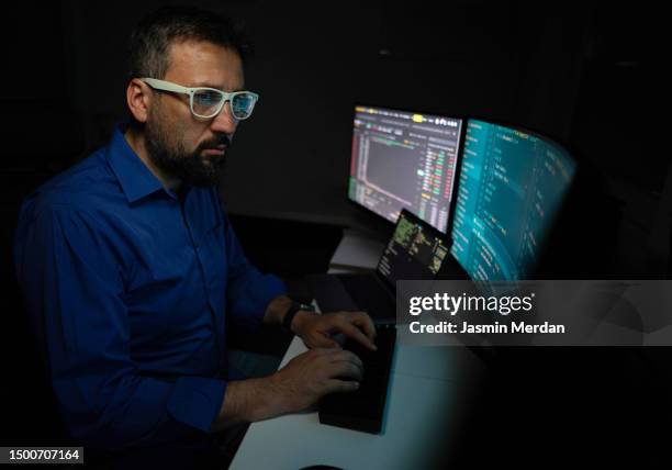 man working on multi displays professional environment - microsoft media & entertainment group stock pictures, royalty-free photos & images