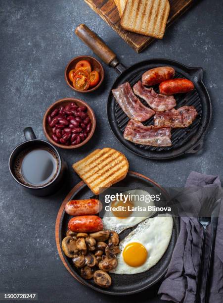 english breakfast - fried egg, beans, tomatoes, mushrooms, bacon and toast. top view - black knob stock pictures, royalty-free photos & images