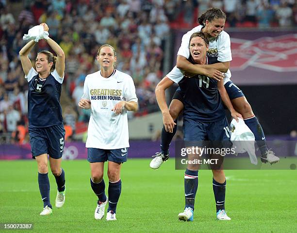 Soccer players Kelley O'Hara , Christie Rampone , Shannon Boxx and Abby Wambach celebrate following a 2-1 victory over Japan in the Olympics women's...