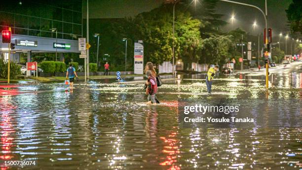 people walk in a flooded intersection in auckland - flood stock pictures, royalty-free photos & images