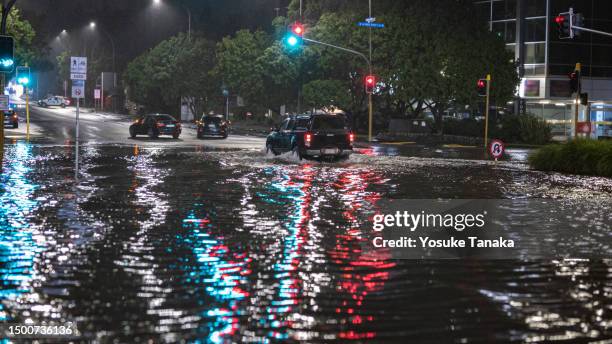 car driving on a flooded intersection in auckland - flood stock pictures, royalty-free photos & images