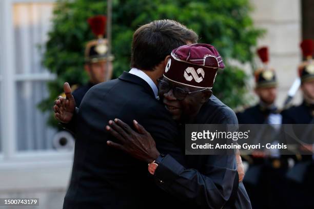 French President Emmanuel Macron greets Nigerian President President Bola Tinubu upon arrival for an official dinner at the Elysee Palace, on the...