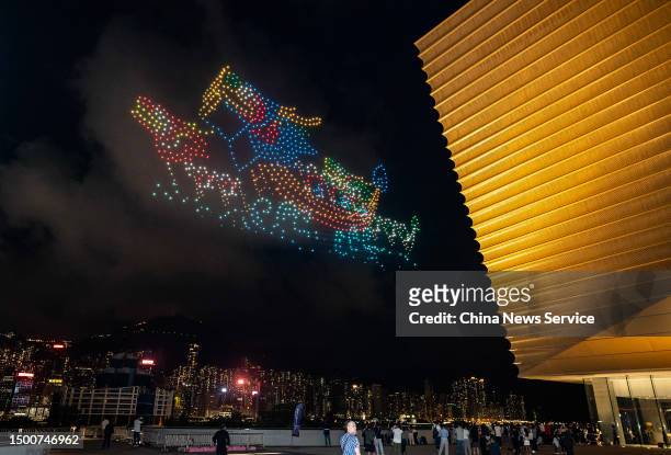 People watch a performance of unmanned aerial vehicles to celebrate the Dragon Boat Festival at Hong Kong Palace Museum on June 22, 2023 in Hong...