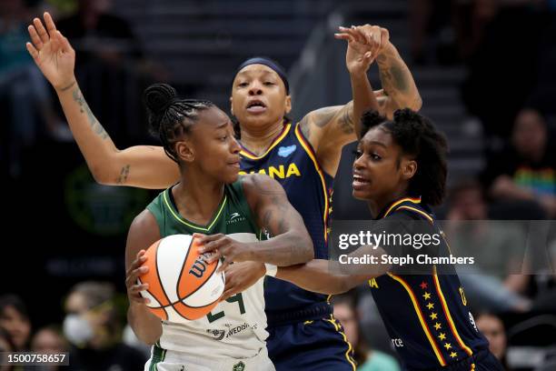 Emma Cannon and Maya Caldwell of the Indiana Fever defend Jewell Loyd of the Seattle Storm during the fourth quarter at Climate Pledge Arena on June...