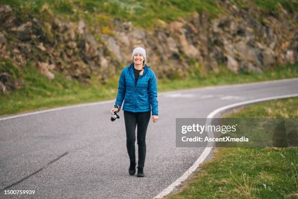 woman walks up rural road - the way forward stock pictures, royalty-free photos & images