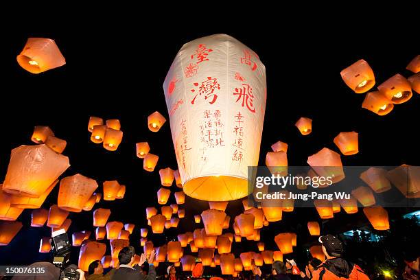 sky lanterns launching into sky - lanterna chinesa imagens e fotografias de stock