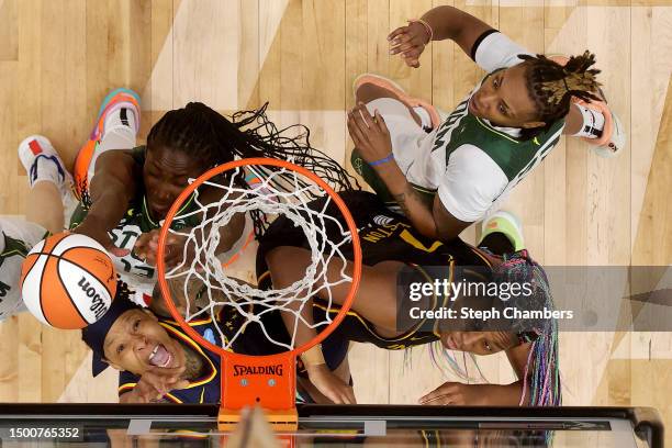 Emma Cannon of the Indiana Fever rebounds with Aliyah Boston against Ezi Magbegor and Jordan Horston of the Seattle Storm during the second quarter...