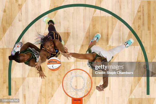 Jewell Loyd of the Seattle Storm, Aliyah Boston of the Indiana Fever, and Mercedes Russell of the Seattle Storm rebound during the second quarter at...