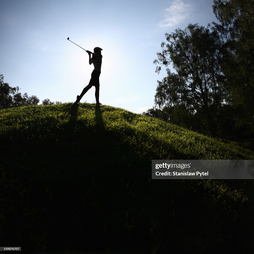 Girl playing golf on hill