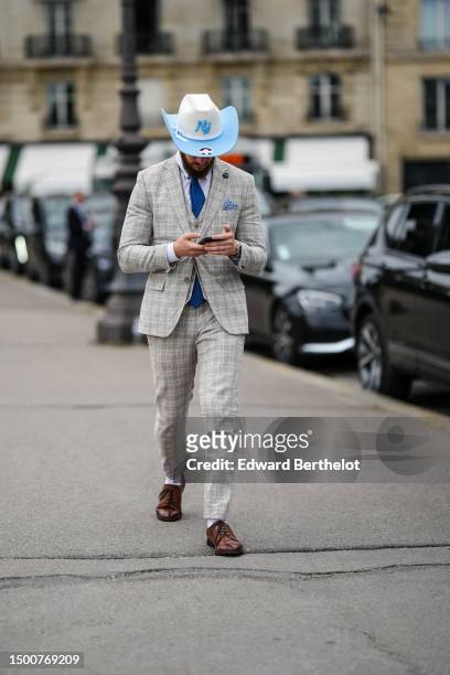 Guest wears a white and pale blue felt wool hat, a navy blue tie, a pale gray checkered print pattern wool blazer jacket, matching pale gray...