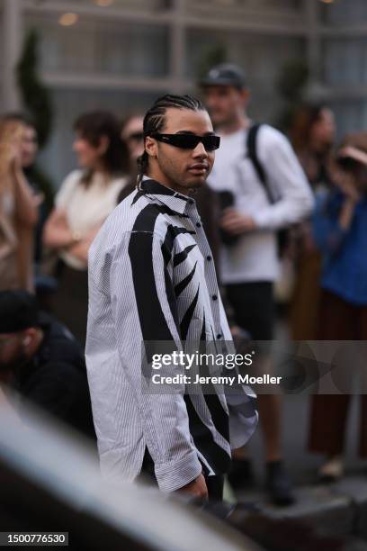 24kGoldn is seen wearing an Inspivia black shades, and light blue and black flanell shirt outside Dries Van Noten during the Menswear Spring/Summer...