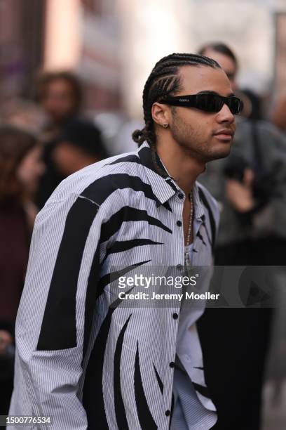 24kGoldn is seen wearing an Inspivia black shades, and light blue and black flanell shirt outside Dries Van Noten during the Menswear Spring/Summer...