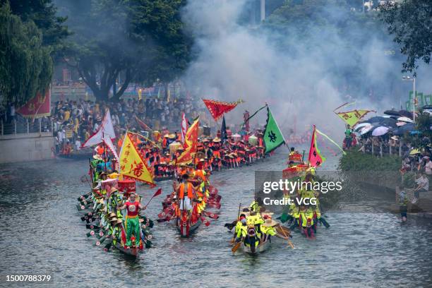 Fireworks explode as participants compete in a dragon boat race to celebrate the Dragon Boat Festival on June 22, 2023 in Guangzhou, Guangdong...