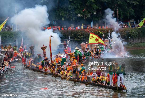 Fireworks explode as participants compete in a dragon boat race to celebrate the Dragon Boat Festival on June 22, 2023 in Guangzhou, Guangdong...