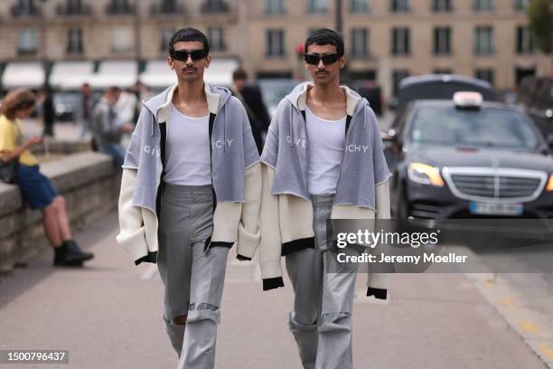 Mohamed Hadban and Humaid Habdan are seen wearing matching outfits with a black shades, white tank top, Givenchy oversized grey logo sweatshirt...