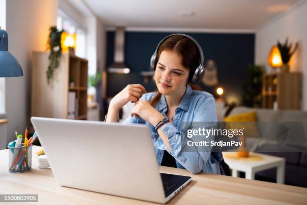 ragazza adolescente con cuffie e laptop con lezione di scuola online a casa - educazione online foto e immagini stock