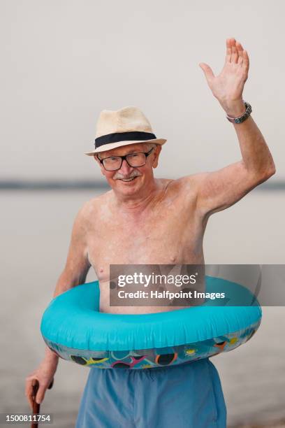 portrait of happy senior man with inflatable wheel. - waving stock pictures, royalty-free photos & images