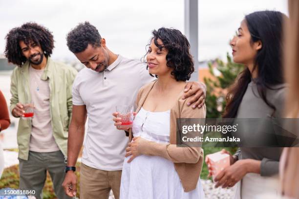 latin expectant mother surrounded by her close friends giving a toast at a gender reveal party outdoors - outdoor baby shower stock pictures, royalty-free photos & images