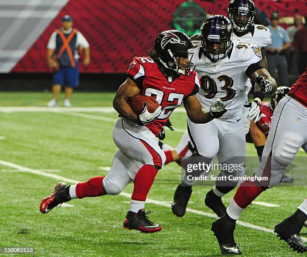 Jacquizz Rodgers of the Atlanta Falcons carries the ball against DeAngelo Tyson of the Baltimore Ravens at the Georgia Dome on August 9, 2012 in...