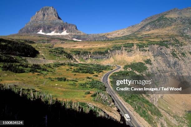 a van descends a mountain pass, glacier national park, mt - going to the sun road stock pictures, royalty-free photos & images