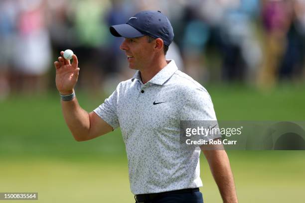 Rory McIlroy of Northern Ireland waves after making a hole-in-one on the eighth hole during the first round of the Travelers Championship at TPC...