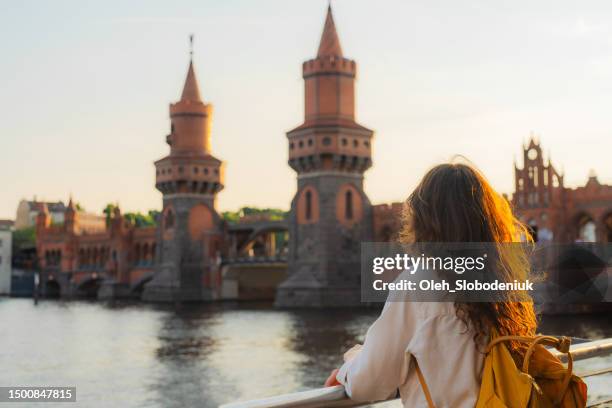 woman walking in berlin at sunset  near oberbaumbrucke bridge - berlin germany stock pictures, royalty-free photos & images