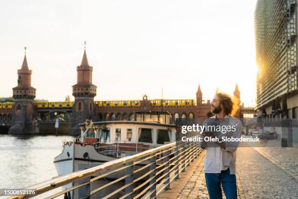 man using smartphone while walking in berlin - berlin tourist stock pictures, royalty-free photos & images