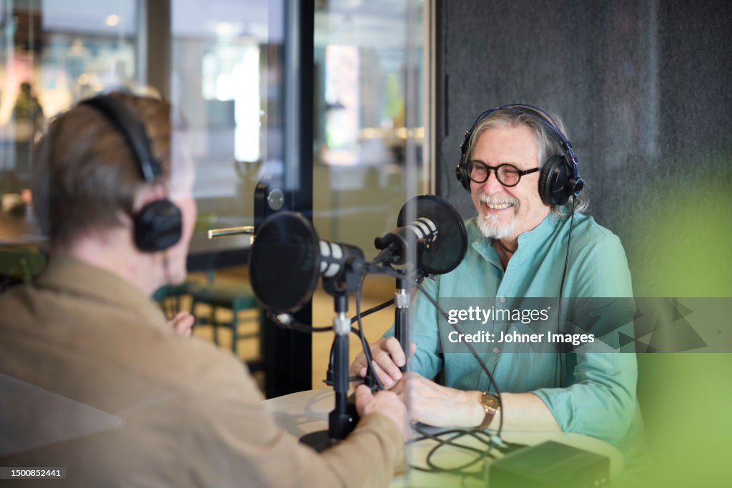 Male radio presenter talking with his guest on radio show or podcast