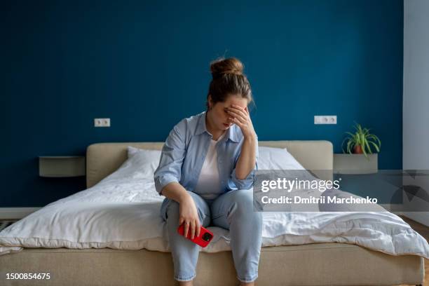 woman with breaking heart crying holding phone after reading breakdown of relations message. - hopelessness stock pictures, royalty-free photos & images