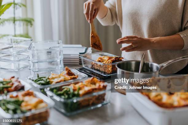 woman weighing lunch boxes as part of healthy meal prep - meal plan stock-fotos und bilder