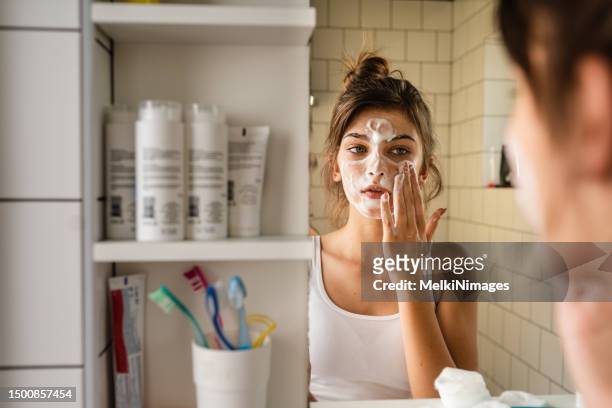 junge frau, die tägliche waschen und reinigen haut routine - gesicht kosmetik maske stock-fotos und bilder