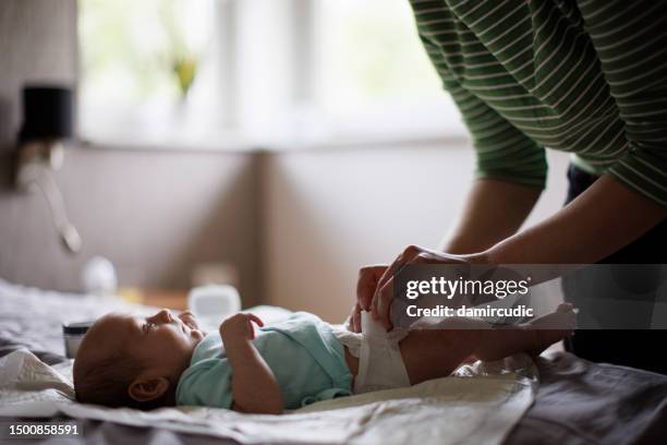 mother changing baby´s diaper - changing diaper stock pictures, royalty-free photos & images