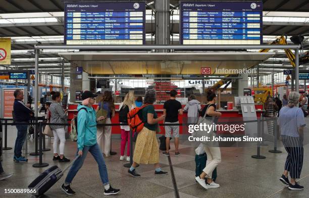 Clients of German state rail carrier Deutsche Bahn walk alongside an information desk at Hauptbahnhof main railway station on June 23, 2023 in...