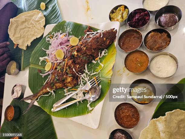 high angle view of a fish and side dishes on white table,vellore,tamil nadu,india - bananenblad stockfoto's en -beelden