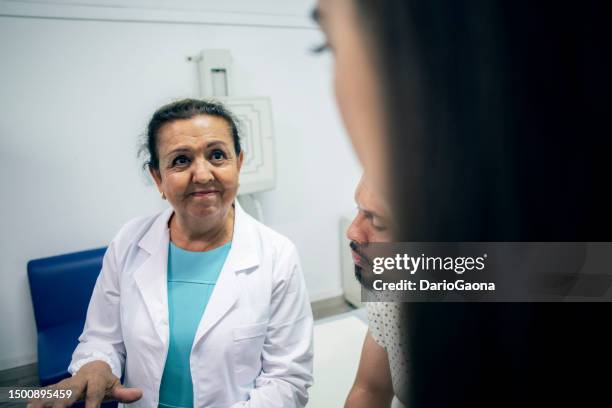 Femal Pacient 120 Female Doctor And Older Female Patient With Family Member Stock ...